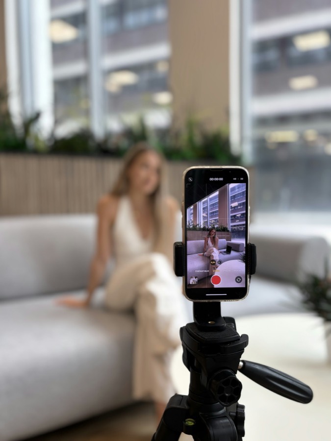 Phone on a tripod filming a host