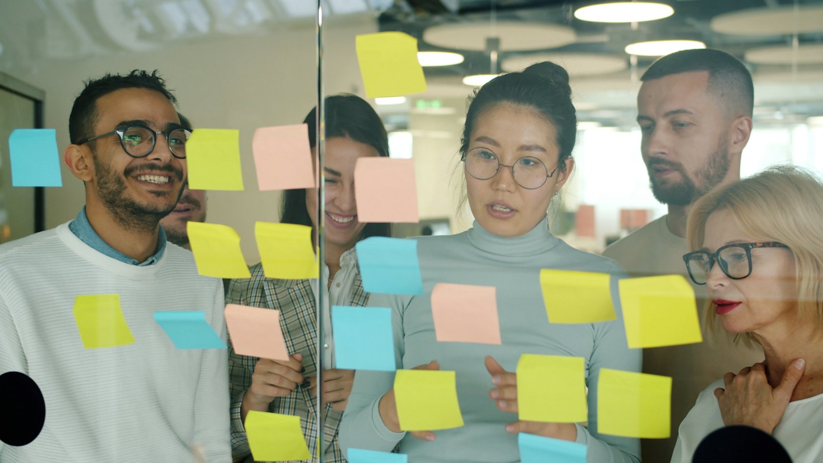 Team brainstorming with sticky notes on a glass wall